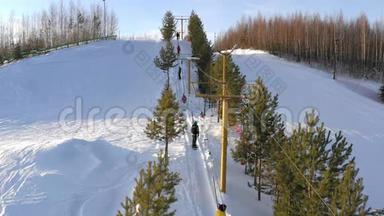 滑雪板在明亮的冬<strong>日升</strong>起。 滑雪者和滑雪者使用滑雪电梯爬山